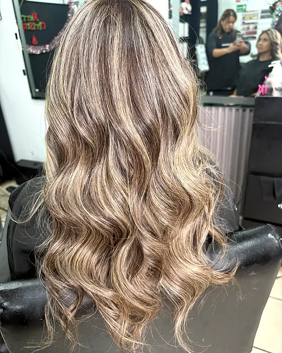 Mechas rubias en ondas sobre base castaña